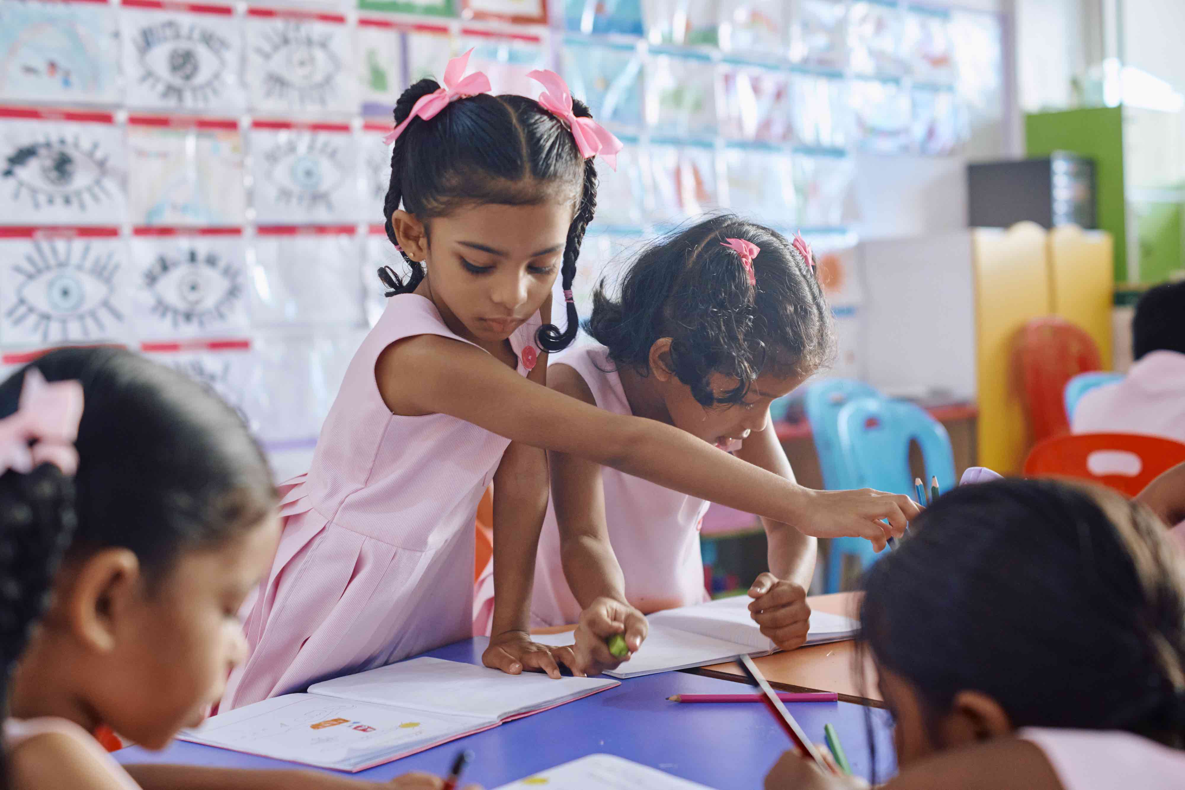 Girls drawing together in class