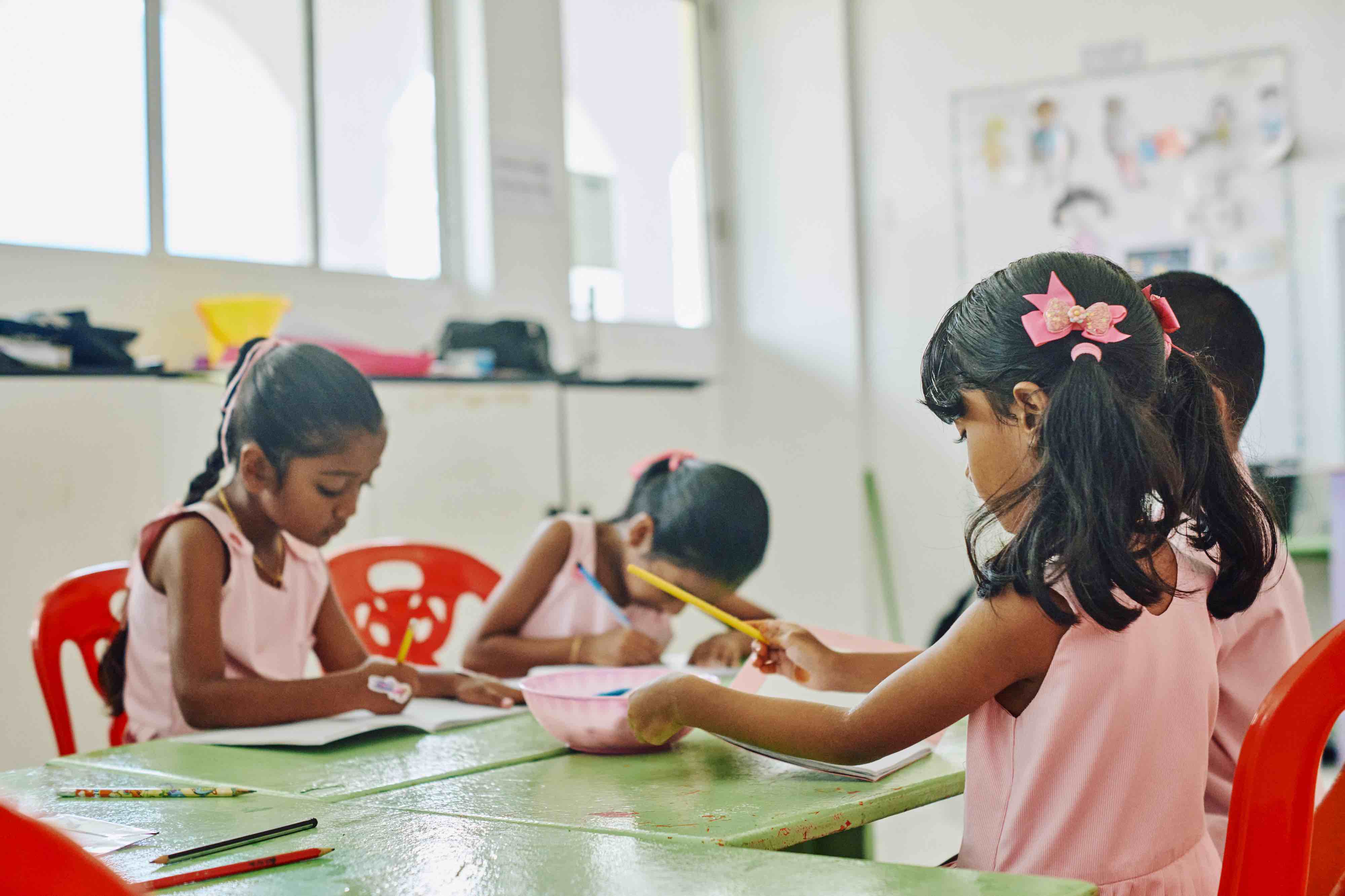 Children drawing together at a classroom table